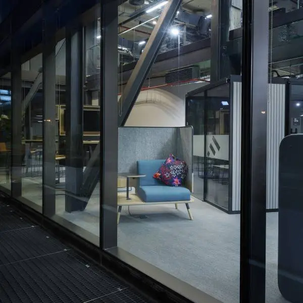 Photo from outside looking in through glass windows at a peacework chair